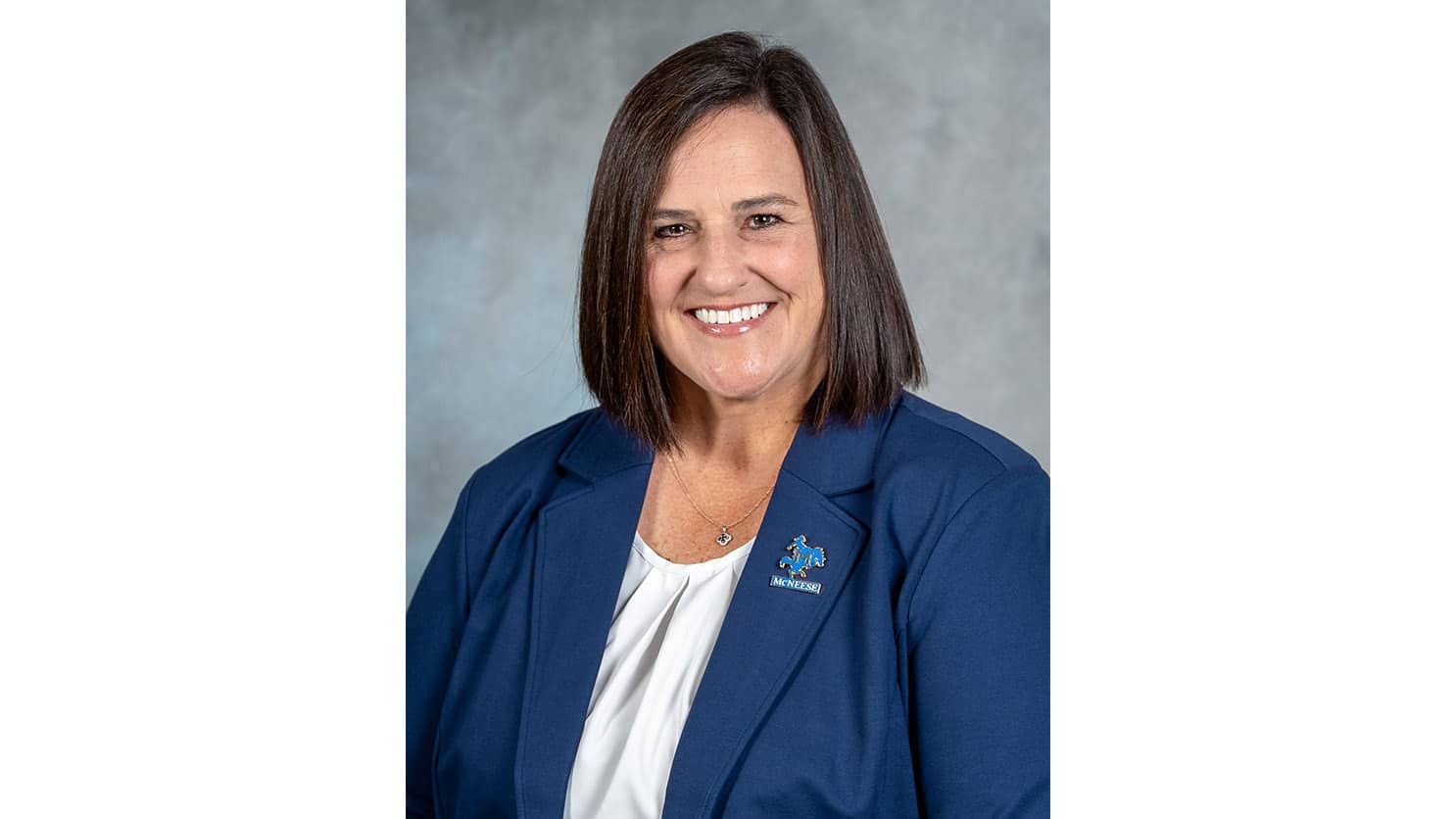 A head and shoulders photo of Jan Robichaux smiling in a blue suit jacket and white blouse.