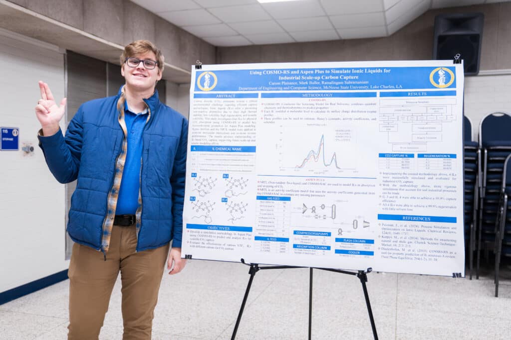 A McNeese student stands next to his research poster at the Undergraduate Research Symposium.