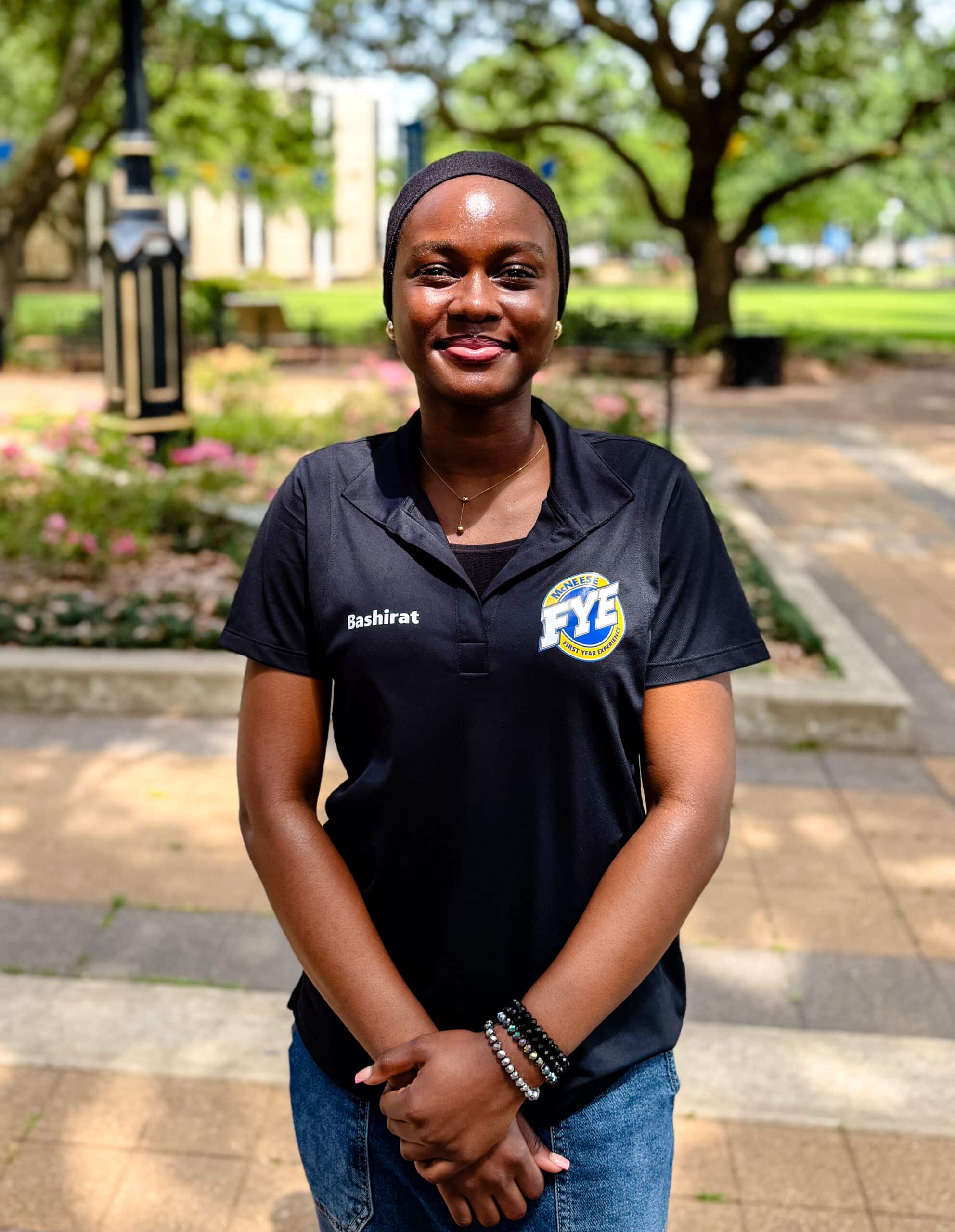 Victoria Clophus smiling outdoors in front of Clock Tower, wearing a black polo.