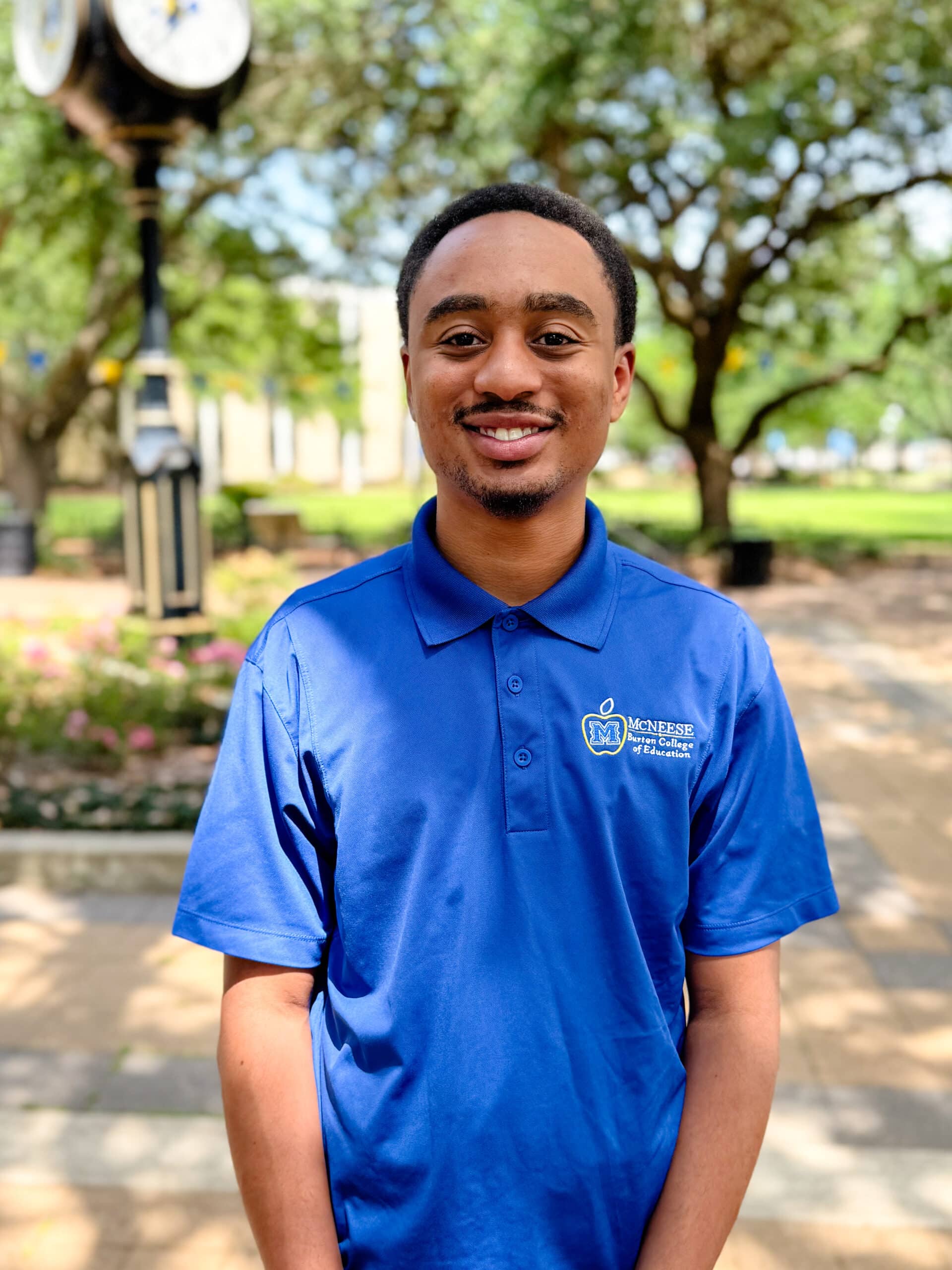 Braylon Fuselier smiling outdoors in front of Clock Tower, wearing a blue polo.