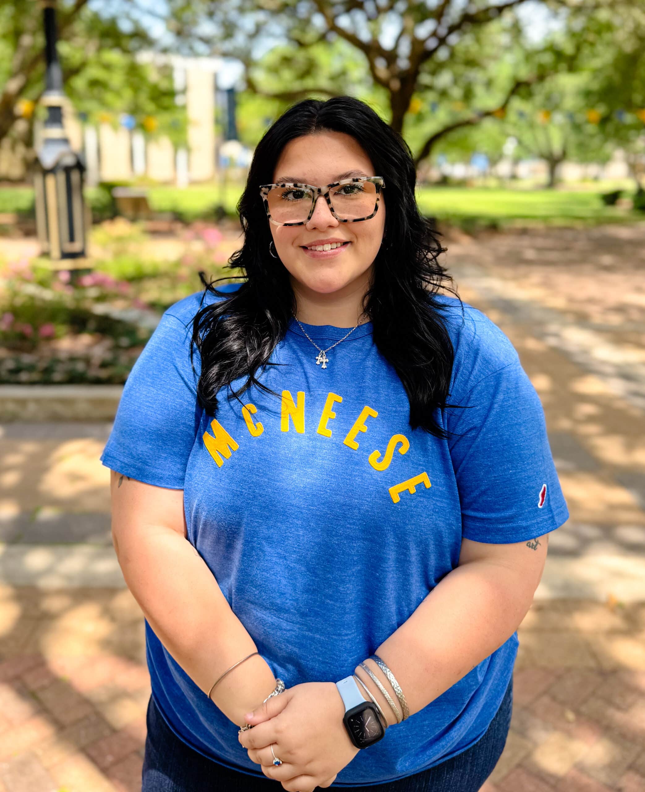 Gabby Rivera smiling outdoors in front of Clock Tower, wearing a blue T-Shirt.